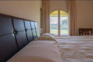 - une chambre avec un grand lit et une grande fenêtre dans l'établissement Villa Profumo, à Campagnano di Roma