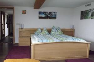 a bedroom with a wooden bed in a room at Ferienwohnung Landblick in Bucha
