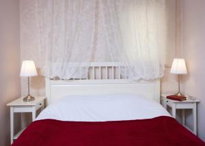 a bedroom with a white bed with two lamps at The Room Hotel & Apartments in Antalya