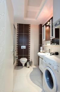 a bathroom with a toilet and a washing machine in it at The Room Hotel & Apartments in Antalya