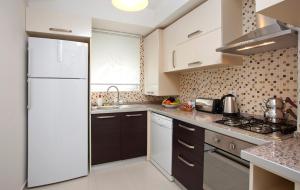 a kitchen with white appliances and a white refrigerator at The Room Hotel & Apartments in Antalya