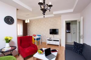 a living room with a couch and a red chair at The Room Hotel & Apartments in Antalya