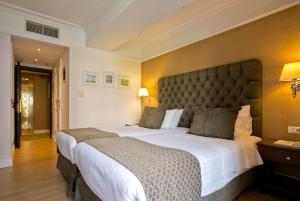 a bedroom with a large bed with a large headboard at Hera Hotel in Athens