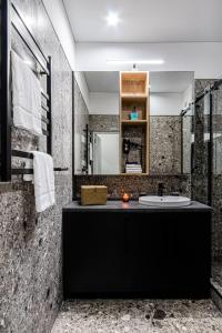 La salle de bains est pourvue d'un comptoir noir et d'un lavabo. dans l'établissement WOL 121 by Ribas, à Odessa