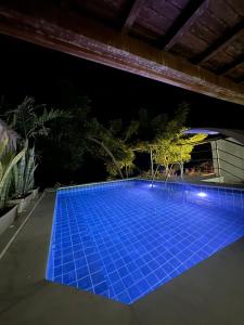 una piscina por la noche con azulejos azules en Pousada ResDelMar en Baía Formosa