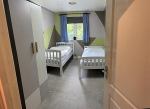ein kleines Zimmer mit 2 Betten und einem Fenster in der Unterkunft Grove flat - two bedroom flat in central Dunstable in Dunstable