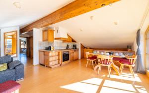 a kitchen and living room with a table and chairs at Ferienwohnung Rauschbergblick in Ruhpolding