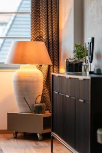 uma lâmpada sentada numa mesa ao lado de uma janela em RentPlanet - Lokum Vena em Breslávia