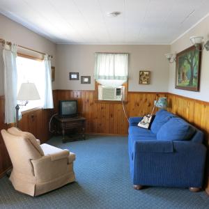sala de estar con sofá azul y silla en The Austin Inn en Lake George