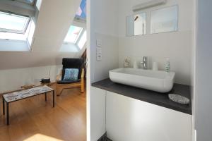 a white bathroom with a sink and a chair at Au Moulin de l'Andelle in Pitres +29 photos