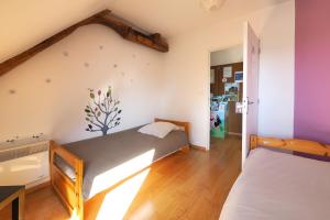 Au Moulin de l'Andelle في Pitres: سريرين في غرفة بجدران أرجوانية وأرضيات خشبية
