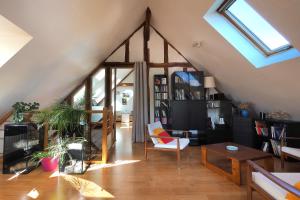 a living room with a vaulted ceiling with a window at Au Moulin de l'Andelle in Pitres