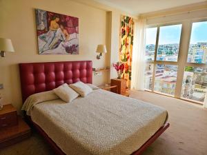 a bedroom with a red bed with a large window at Luxury House Relax - Alojamientos La Torre in Torre del Mar