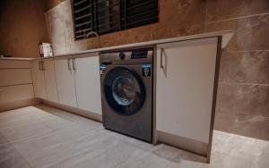 a laundry room with a washing machine in a kitchen at Big chill stays in Accra