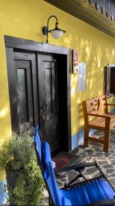 a porch with a blue chair in front of a door at Boutique Tourist Farm Hrovat in Frankolovo