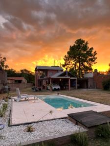 ein Haus mit einem Pool vor einem Sonnenuntergang in der Unterkunft La Casa del Escritor in Colastiné