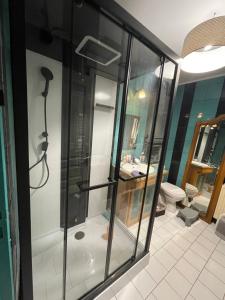 a glass shower in a bathroom with a toilet at Chambre privée cosy in Noyon