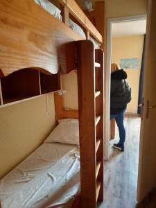 una persona in piedi in una camera con un letto a castello di Appartement carlines 1 les ménuires a Les Menuires
