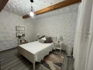 a white bedroom with a bed and a table at Casa Rural Juli in Santa Cruz de Tenerife