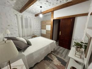 a bedroom with a white bed and a window at Casa Rural Juli in Santa Cruz de Tenerife