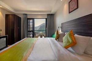 a hotel room with a large bed with a view at Sterling Nainital in Nainital