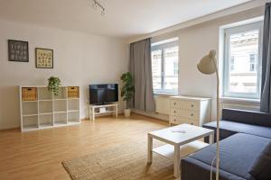 a living room with a couch and a tv at Central Living Apartments - Schottentor in Vienna