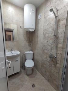 y baño con ducha, aseo y lavamanos. en Cozy Rooms Panagyurishte, en Panagyurishte