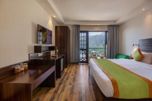 a hotel room with a large bed and a balcony at Sterling Nainital in Nainital