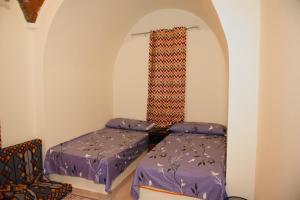um pequeno quarto com 2 camas e uma janela em قرية تونس السياحية em Tunis