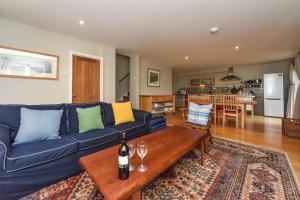 哈廷頓的住宿－Raikes Barn，客厅配有蓝色的沙发和木桌