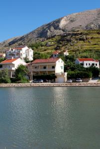 a group of houses next to a body of water at Lokunja Bed&Breakfast in Pag