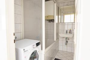 eine Waschmaschine im Bad mit Waschbecken in der Unterkunft Central Living Apartments - Schottentor in Wien