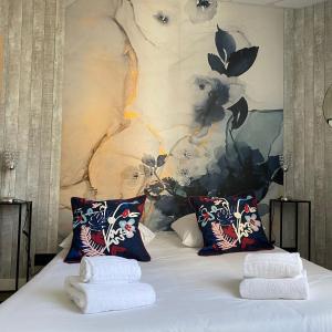 1 dormitorio con 1 cama con 2 toallas en Résidence Vendôme, en Vichy