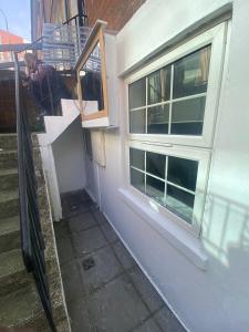 an open window on a house with a stair case at Cosy Hideaway Close to Town in Reading