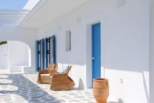 a room with wicker chairs and a blue door at Villa Omega Guest House in Kokkali, Leros in Gourna