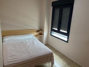 - une petite chambre avec un lit et une fenêtre dans l'établissement Hostal Restaurant El Poligono, à Valence