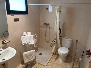 La salle de bains est pourvue d'une douche, de toilettes et d'un lavabo. dans l'établissement Hostal Restaurant El Poligono, à Valence