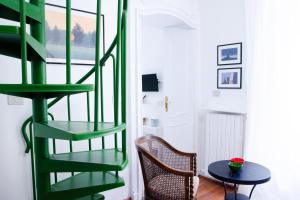 a green spiral staircase in a room with a table at Il nido sulla Mole in Turin