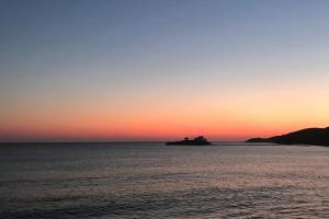 an island in the ocean at sunset at Villa Omega Guest House in Kokkali, Leros in Gourna