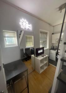 ein Wohnzimmer mit einem Schreibtisch, einem TV und einer Küche in der Unterkunft Quirky Studio Camden in London
