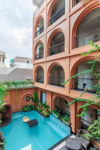 an external view of a building with a swimming pool at The Red Pier by Downtown Udaipur in Udaipur