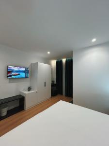 a bedroom with a bed and a flat screen tv at Clinton Tirana Inn in Tirana