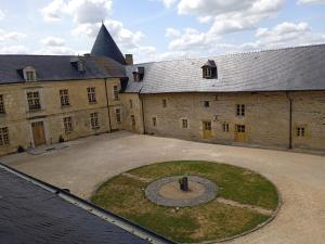 un edificio antiguo con un círculo en medio de un patio en 3 Gîtes avec piscine au Château de Charbogne, 