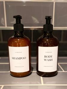 two bottles of shampoo and body wash sitting on a shelf at Regent’s Park / Marylebone Studio Flat in London