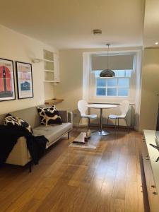 a living room with a couch and a table at Regent’s Park / Marylebone Studio Flat in London