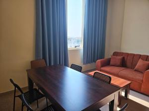 un soggiorno con tavolo e divano di Oasis Hostel a Abu Dhabi