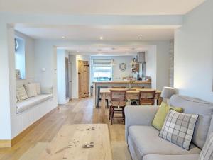 a living room with a couch and a table at Spence Cottage, Birdham in Birdham