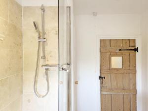 a bathroom with a shower with a glass door at Spence Cottage, Birdham in Birdham +15 photos