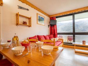 un soggiorno con tavolo e ciotole sopra di Apartment Brelin Evons 409 by Interhome a Les Menuires
