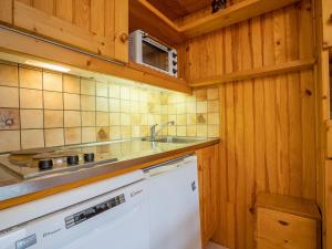 a kitchen with a sink and a white dishwasher at Apartment Brelin-5 by Interhome in Les Menuires